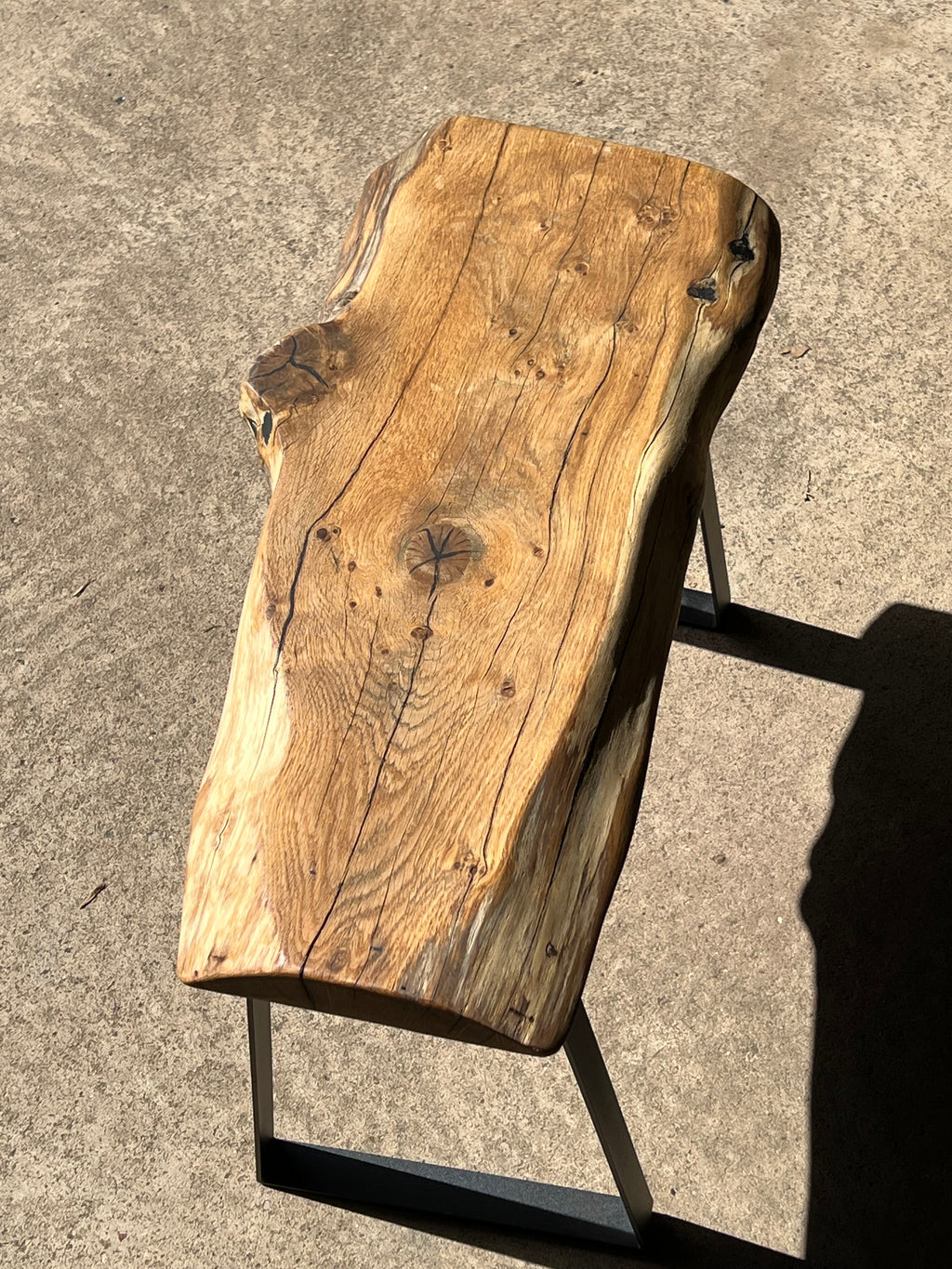 Wooden bench with a natural finish on a concrete surface